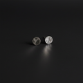 A pair of small round stud earrings with a hammered silver finish, displayed on a dark, reflective surface.