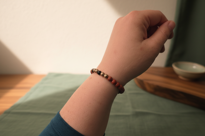 Hand wearing a beaded bracelet with a blurred background