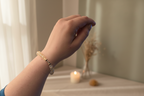 Hand holding a hair accessory with a background of jewelry displays