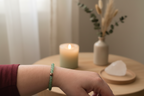 Woman’s wrist wearing the Verdant Mercy Bracelet by Jewellery by JN, with matte aventurine and a silver accent bead.