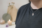 Woman’s neck wearing the Elemental Balance Necklace by Jewellery by JN, with hammered silver and copper pendant.