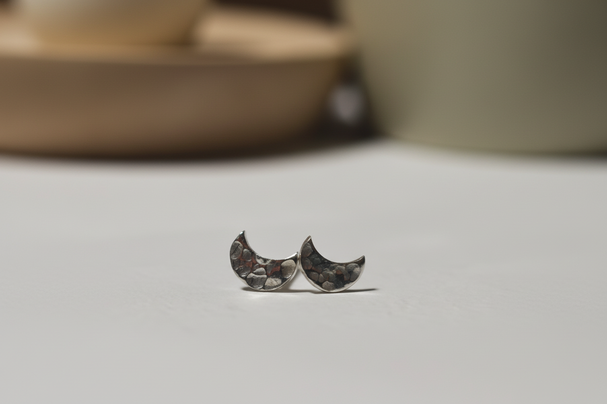 Crescent moon-shaped earrings on a neutral background