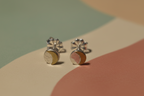 Pair of silver earrings with a gold accent on a multicolored background