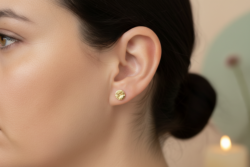 Woman wearing Golden Charm Studs by Jewellery by JN, showing the golden brass texture and minimalist style.