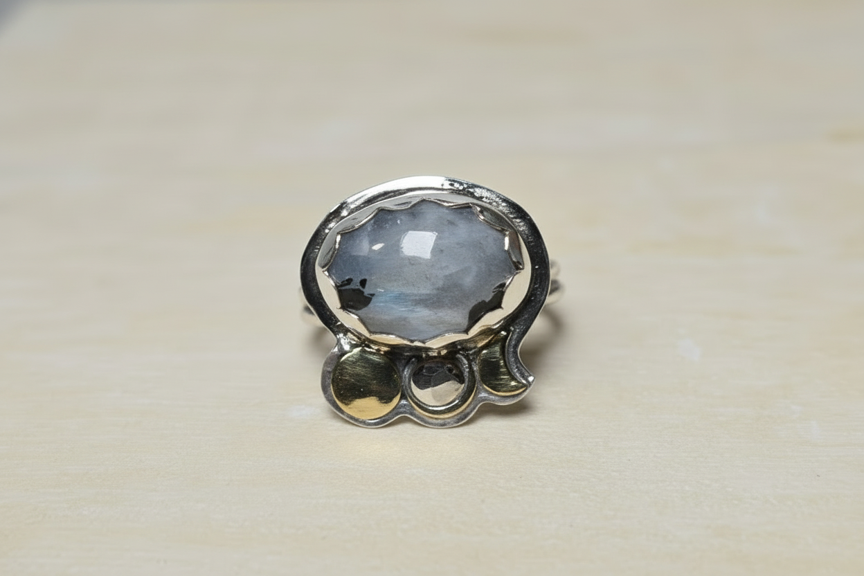 Silver ring with a large gemstone on a beige background