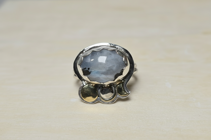 Silver ring with a large gemstone on a beige background