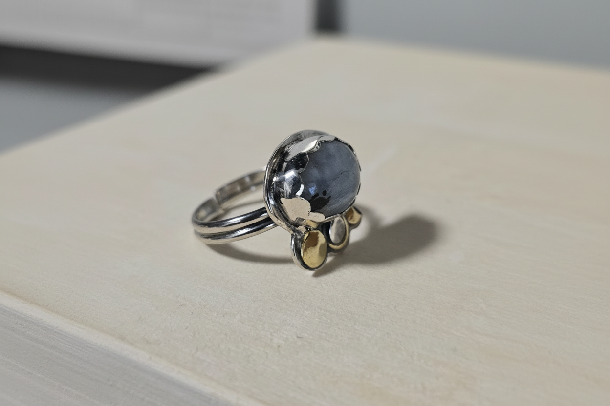 Silver ring with a blue gemstone on a white surface