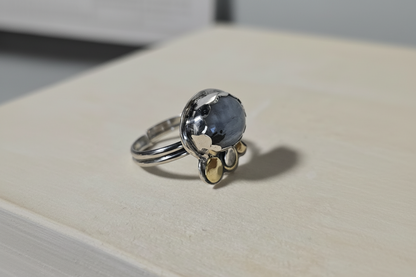 Silver ring with a blue gemstone on a white surface