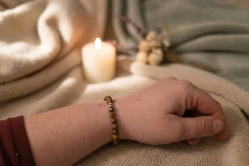 Woman’s wrist wearing the Emberroot Bracelet by Jewellery by JN, with Iron Zebra Jasper and sterling silver accent beads.