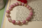 Pink beaded bracelet on an open book