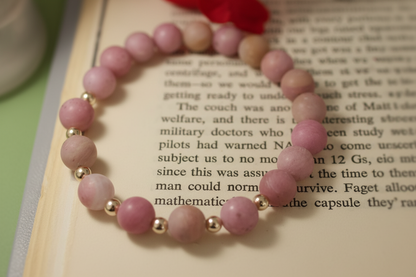 Pink beaded bracelet on an open book