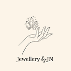Logo of 'Jewellery by JN' featuring a hand holding crystals on a beige background.