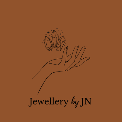 Illustration of a hand holding crystals with 'Jewellery by JN' text on a brown background