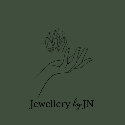 Logo of 'Jewellery by JN' featuring a hand holding crystals on a beige background.