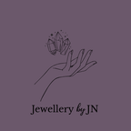 Logo of 'Jewellery by JN' featuring a hand holding crystals on a beige background.