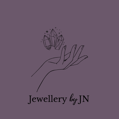 Logo of 'Jewellery by JN' featuring a hand holding crystals on a beige background.