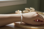 Woman’s wrist wearing the Lumenveil Bracelet by Jewellery by JN, with matte clear quartz beads and a silver accent bead.