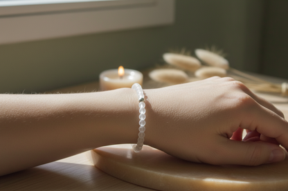Woman’s wrist wearing the Lumenveil Bracelet by Jewellery by JN, with matte clear quartz beads and a silver accent bead.