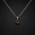 A silver chain necklace with a round pendant featuring a dark brown tiger's eye stone in a silver bezel setting, displayed against a dark textured background.