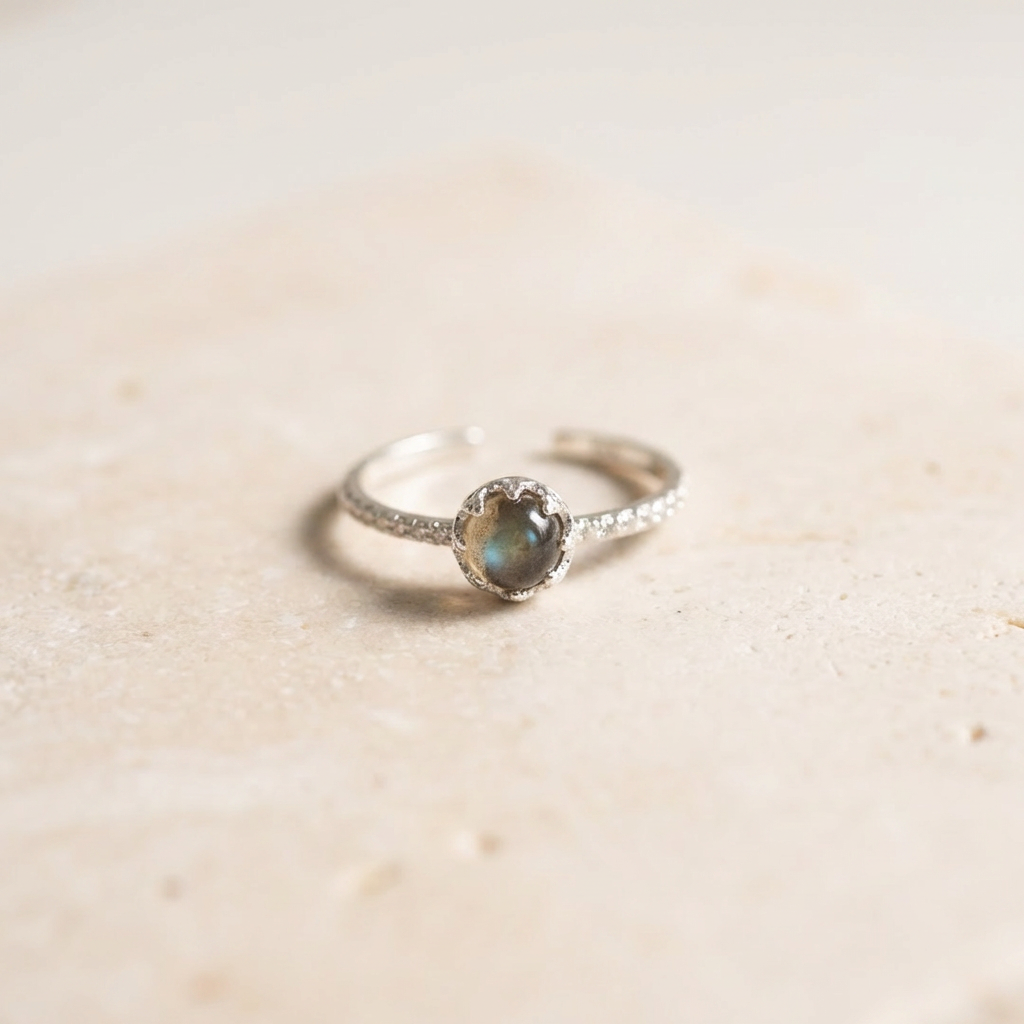 Silver ring with a gemstone on a beige background