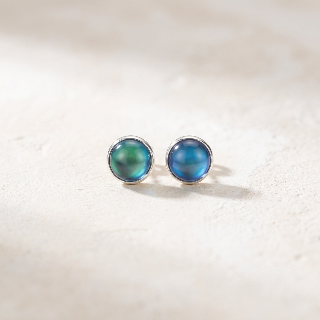 Pair of blue round stud earrings on a light beige background