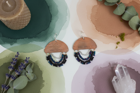 Mini Wordkeeper Earrings Protected by Jewellery by JN, hand-forged copper with black, multicolour, and silver seed bead fringe and handmade sterling silver ear wires, shown front-facing.