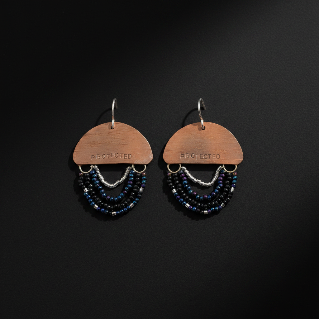 A pair of handmade dangle earrings on a dark black background. Each earring features a copper-colored metal semicircle stamped with the word 'PROTECTED' and hangs from silver hooks.