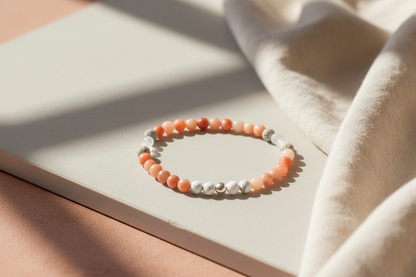 Veilbalance Bracelet styled with flowers and ritual props, featuring howlite, peach aventurine, matte clear quartz, grey volcanic rock, and sterling silver, Jewellery by JN."
