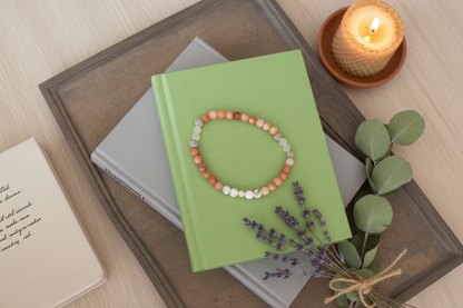 "Flat lay of Veilbalance Bracelet with white, peach, clear, and grey gemstone beads and a single sterling silver bead at the centre, ritual jewellery by JN.