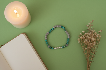 Wayfinder Bracelet by Jewellery by JN, featuring African turquoise, grey lava rock, and sterling silver beads, arranged in a flat lay on a neutral background.