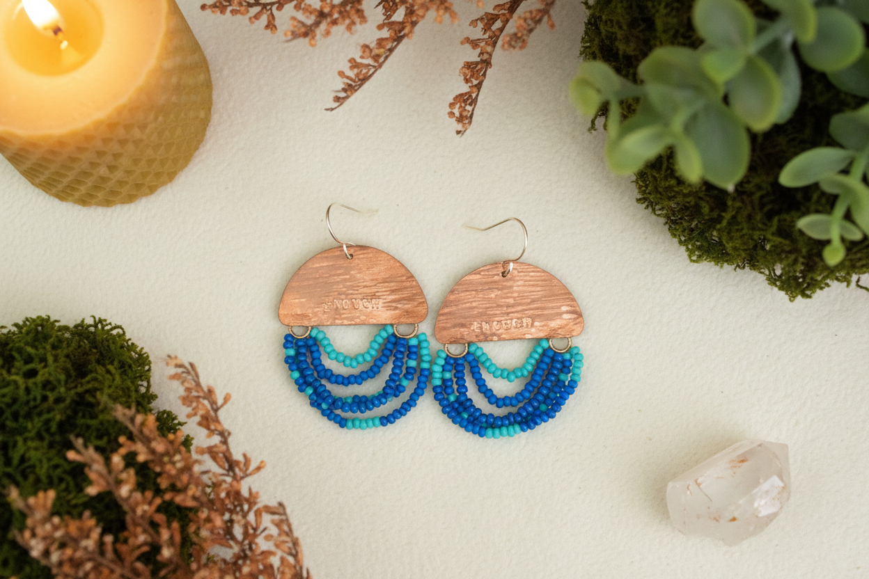 Mini Wordkeeper Earrings Enough by Jewellery by JN, hand-forged copper with layered blue seed bead fringe and handmade sterling silver ear wires, shown front-facing.