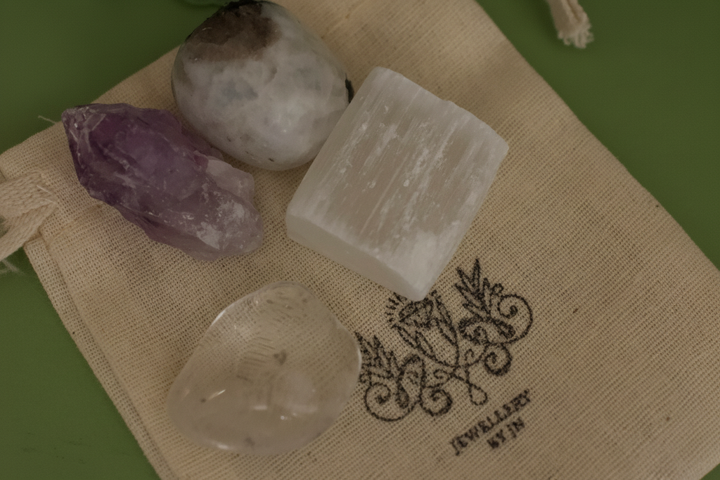 Close-up of tumbled gemstones from Full Moon Gemstone Bag by Jewellery by JN, showing Moonstone, Amethyst, Selenite, and Clear Quartz.