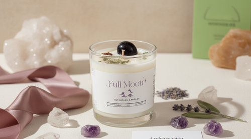 Full Moon Intention Candle by Jewellery by JN, hand-poured candle with Moonstone and Amethyst crystals, cedar leaf, star anise, mugwort, black salt, and silver shimmer, displayed on creamy linen with ritual props.