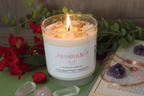 Gratitude Intention Candle by Jewellery by JN, lit with glowing flame, showing Rose Quartz and Citrine crystals embedded in wax