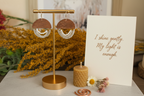 Mini Wordkeeper Earrings Light by Jewellery by JN in branded packaging with a handwritten affirmation card and ritual props on an earthy background.