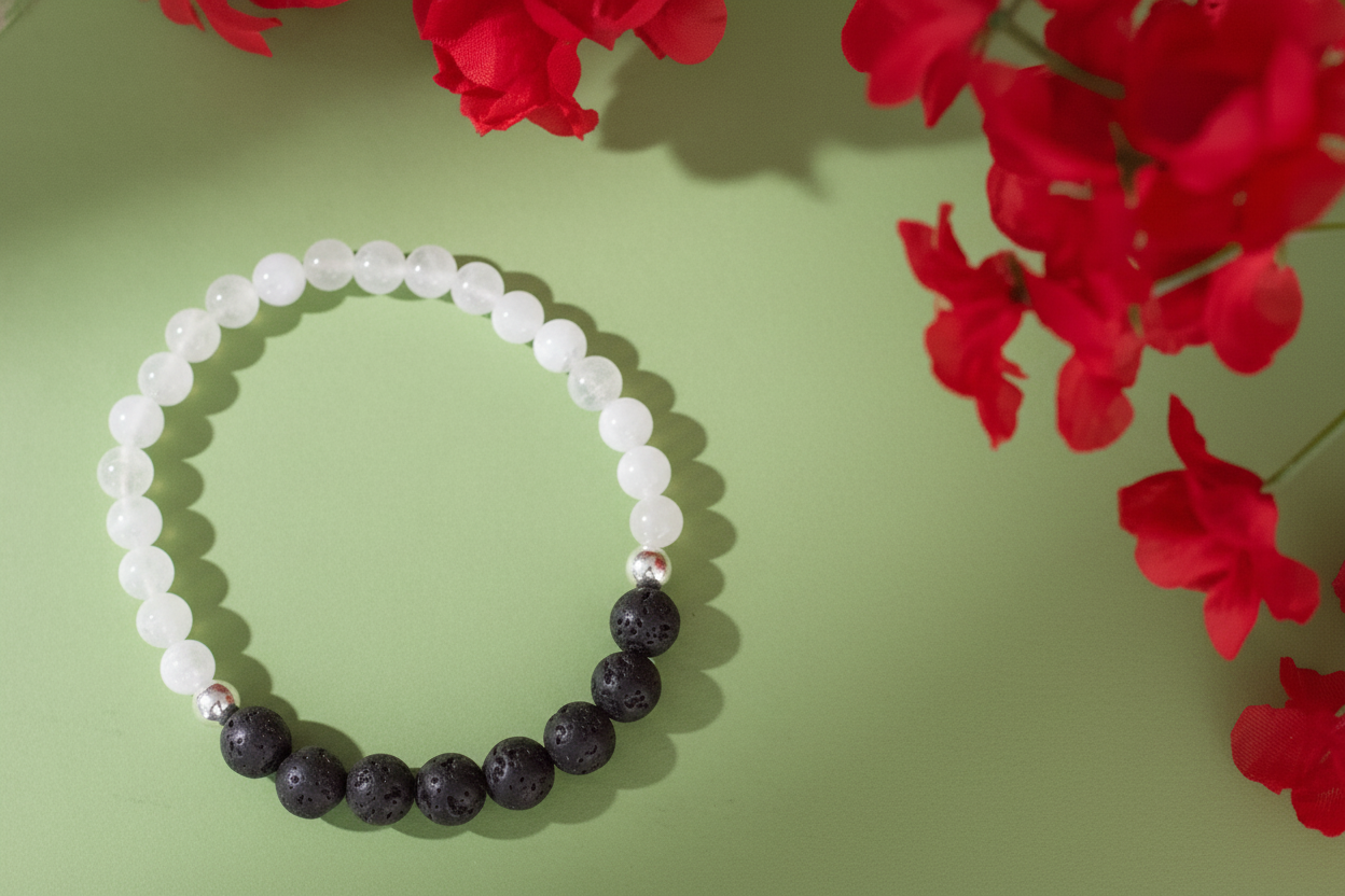 Beaded bracelet with white and black beads on a green background with red flowers