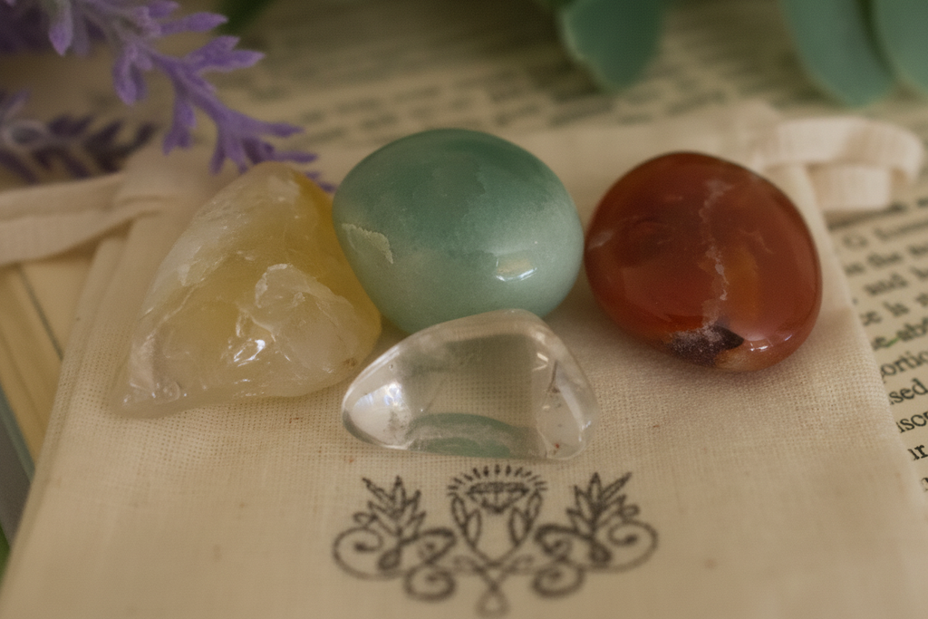 "Close-up of tumbled gemstones from Manifestation Gemstone Bag by Jewellery by JN, showing Citrine, Carnelian, Green Aventurine, and Clear Quartz."