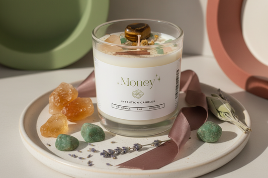 Money Intention Candle by Jewellery by JN, hand-poured candle with Green Aventurine, Citrine, and Tiger's Eye crystals, chamomile flowers, mint, cinnamon, and gold shimmer, displayed on creamy linen with ritual props.
