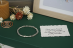 Starveil Bracelet by Jewellery by JN with handwritten affirmation card, styled with ritual props on a creamy background