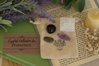 Protection Gemstone Bag by Jewellery by JN, recycled cotton pouch with tumbled Labradorite, Amethyst, Snowflake Obsidian, and Selenite, displayed on creamy linen with ritual props.