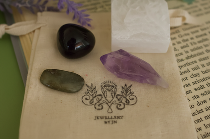 Close-up of tumbled gemstones from Protection Gemstone Bag by Jewellery by JN, showing Labradorite, Amethyst, Snowflake Obsidian, and Selenite.