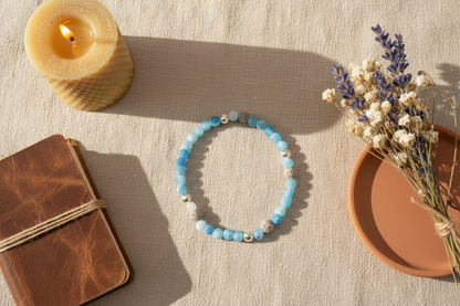 "Shadowcurrent Bracelet styled with ritual props, featuring blue agate, grey volcanic rock, and silver beads, Jewellery by JN."