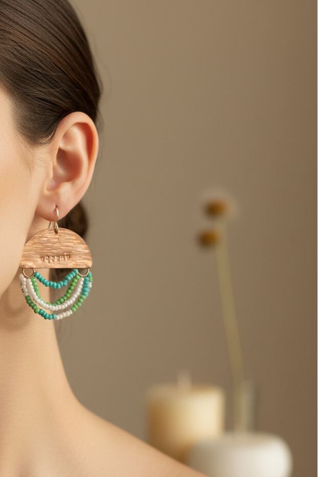 Woman wearing Mini Wordkeeper Earrings Worthy by Jewellery by JN, showing copper, green, teal, and white bead fringe, and silver ear wires.