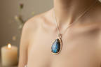 Woman’s neck wearing the Emberheart Pendant by Jewellery by JN, with teardrop labradorite, copper backplate, and silver chain.