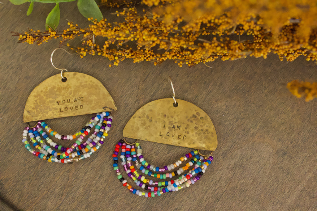Close-up of Half Moon Wordkeeper Earrings Loved by Jewellery by JN, highlighting hammered brass, beadwork, and hand-stamped affirmations